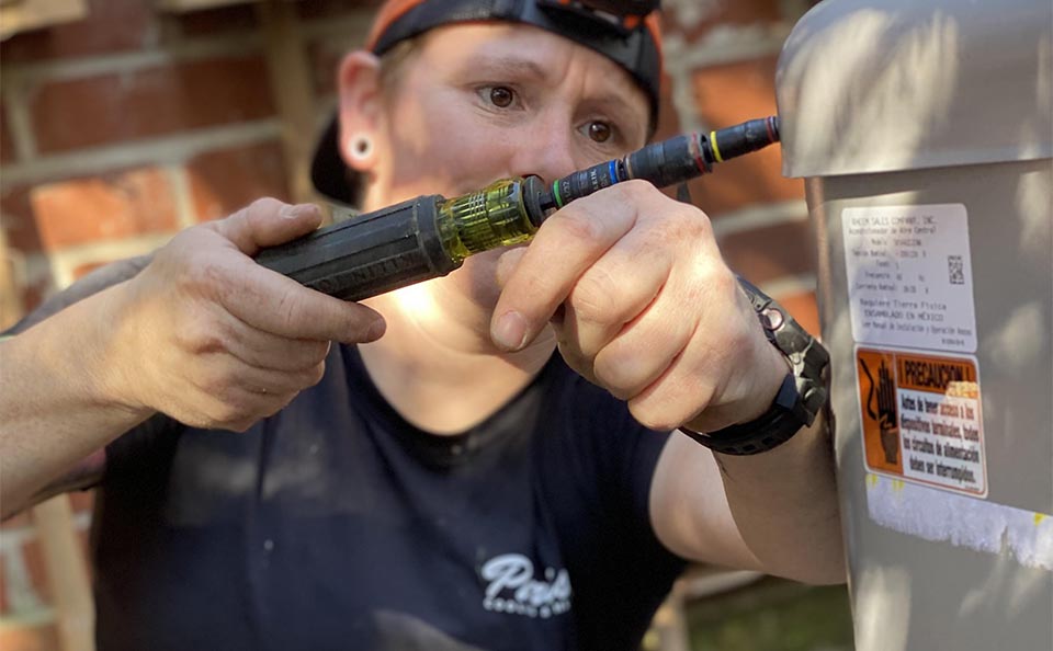 Parish worker repairing an AC unit