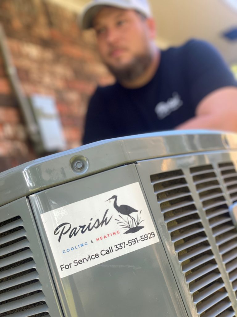 Parish worker standing besides an AC unit